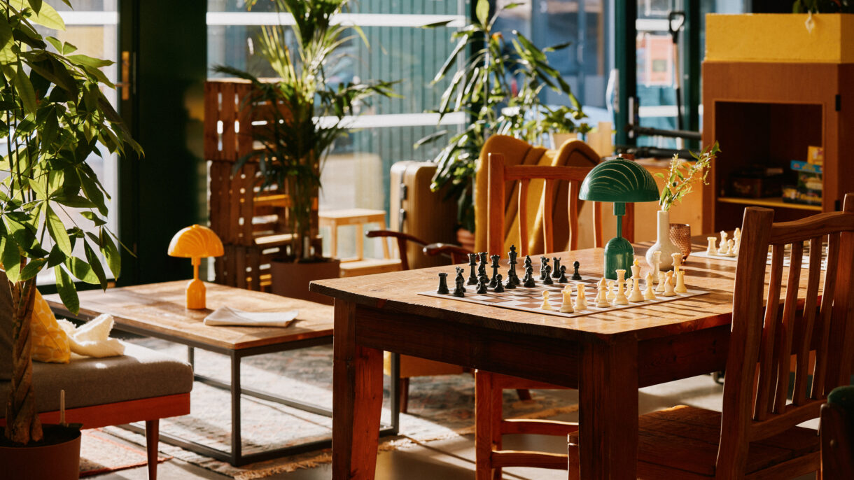 Interiør med bord, stoler og sjakkbrett.